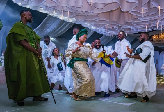 A group of people in traditional clothing dancing joyfully at a celebration.